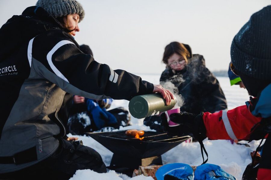 Rovaniemi: Ice Fishing & Snowmobile Safari Combo Day - Drilling into a frozen lake